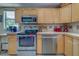 This kitchen is equipped with stainless steel appliances, wood cabinets, and stone-look countertops at 3504 N 12Th St, Tampa, FL 33605