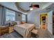 Comfortable main bedroom featuring a tray ceiling, fan, carpeted floors, and natural light from the large window at 3504 N 12Th St, Tampa, FL 33605