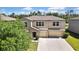 Two-story home featuring a three-car garage, neutral stucco exterior, and well-maintained landscaping at 35965 Saddle Palm Way, Zephyrhills, FL 33541