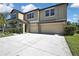 Two-story home features a three-car garage, neutral stucco exterior, and well-maintained landscaping at 35965 Saddle Palm Way, Zephyrhills, FL 33541