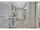 Inviting foyer features a stylish console table against a white brick accent wall with tile flooring at 35965 Saddle Palm Way, Zephyrhills, FL 33541