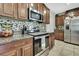 Close-up of the kitchen featuring stainless steel appliances, granite countertops, and decorative backsplash at 35965 Saddle Palm Way, Zephyrhills, FL 33541