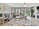 View of the living room with a decorative fireplace and large windows that offer a beautiful view at 35965 Saddle Palm Way, Zephyrhills, FL 33541