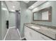 Bathroom with modern vanity, granite countertop, decorative mirror, and a walk-in shower at 4319 Harbor House Dr, Tampa, FL 33615