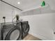 Laundry room featuring a front loading washer, dryer, wire shelving, and tile floor at 4319 Harbor House Dr, Tampa, FL 33615