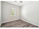Bright bedroom featuring wood-look floors, neutral walls, and a window with natural light at 4559 Mitcher Rd, New Port Richey, FL 34652