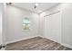 Bright bedroom with wood-look flooring, closet, and natural light from the window at 4559 Mitcher Rd, New Port Richey, FL 34652