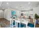 Open concept dining room featuring a white wood table with seating for six and a view of the kitchen at 4559 Mitcher Rd, New Port Richey, FL 34652
