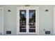 Close-up of the front double door entrance, with green walls and modern lighting fixtures at 4559 Mitcher Rd, New Port Richey, FL 34652