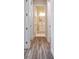 Hallway with wood-look flooring leading to a bright bathroom at 4559 Mitcher Rd, New Port Richey, FL 34652
