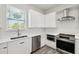 Bright kitchen featuring stainless steel appliances and white cabinetry at 4559 Mitcher Rd, New Port Richey, FL 34652