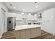 Modern kitchen boasts white cabinets, stainless steel appliances, and a large island with wood accents at 4559 Mitcher Rd, New Port Richey, FL 34652