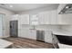 Bright kitchen featuring white cabinets, stainless steel appliances, and quartz countertops for a sleek design at 4559 Mitcher Rd, New Port Richey, FL 34652