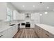 Contemporary kitchen featuring white cabinets, an island, stainless steel appliances, and wood-look flooring at 4559 Mitcher Rd, New Port Richey, FL 34652