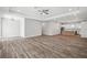 Open-concept living room with wood-look floors and modern kitchen with stainless steel appliances at 4559 Mitcher Rd, New Port Richey, FL 34652