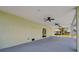 View of the spacious covered patio, featuring ceiling fans, leading to the outside at 4559 Mitcher Rd, New Port Richey, FL 34652