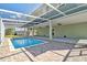 Backyard pool area with screened in enclosure and brick paver patio at 4559 Mitcher Rd, New Port Richey, FL 34652