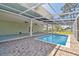Backyard pool with covered patio and brick pavers at 4559 Mitcher Rd, New Port Richey, FL 34652
