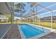 Backyard pool area with screened in enclosure and brick paver patio at 4559 Mitcher Rd, New Port Richey, FL 34652