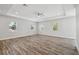 Spacious room featuring hardwood floors, a ceiling fan and three windows at 4559 Mitcher Rd, New Port Richey, FL 34652