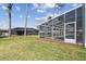 View of backyard with screened pool and ample green space at 4559 Mitcher Rd, New Port Richey, FL 34652