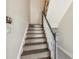 Interior view of a staircase with wooden steps, white risers, and a gray handrail at 4559 Mitcher Rd, New Port Richey, FL 34652