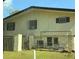 Exterior elevation view with the two story structure, weathered facade and fenced yard at 4628 Cypress S Way, St Petersburg, FL 33705