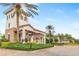 View of the community entrance featuring an arched entry, stone accents, and tropical landscaping at 4824 Benito Ct, Bradenton, FL 34211
