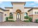 Close up view of a home's facade, with a decorative front door, architectural pillars, and manicured greenery at 4824 Benito Ct, Bradenton, FL 34211