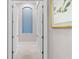 Hallway features neutral paint and carpet, with an arched niche and framed artwork at 4824 Benito Ct, Bradenton, FL 34211