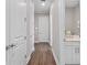 Hallway with hardwood floors, white doors, and a partial view of the bathroom at 4824 Benito Ct, Bradenton, FL 34211