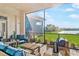 Inviting screened-in patio with cozy seating and a scenic view of the lake and surrounding greenery at 4824 Benito Ct, Bradenton, FL 34211
