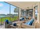 Screened-in patio with comfortable seating, offering beautiful views of the lake and lush landscape at 4824 Benito Ct, Bradenton, FL 34211