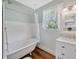 Charming bathroom with a clawfoot tub, window, wainscoting, and vintage-style fixtures at 5912 N Lynn Ave, Tampa, FL 33604