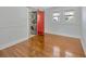Bright bedroom features hardwood floors, two windows with views, plus a red sliding door to the laundry at 5912 N Lynn Ave, Tampa, FL 33604