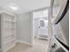 View of laundry room leading to a bathroom; features built in shelving, tiled floors, and stacked washer and dryer at 5912 N Lynn Ave, Tampa, FL 33604