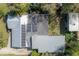 Aerial view of a home with solar panels, lush yard, and detached structures surrounded by trees at 604 W Hilda St, Tampa, FL 33603