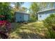 Private backyard with lush landscaping, detached buildings, and cozy fire pit area for outdoor relaxation at 604 W Hilda St, Tampa, FL 33603