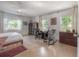 This bright bedroom includes a bed, desk area, and large windows overlooking tropical foliage at 604 W Hilda St, Tampa, FL 33603