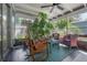 Enclosed porch features comfortable seating and views of the tropical foliage at 604 W Hilda St, Tampa, FL 33603
