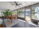 Bright sunroom featuring a dining table set with wicker chairs and views of the landscaped backyard at 604 W Hilda St, Tampa, FL 33603