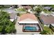 Aerial view showcasing the property's pool, screened-in lanai, and landscaped yard in a residential setting at 6716 Frontier Ln, Tampa, FL 33625