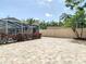 Spacious backyard featuring decorative brick pavers, privacy wall, tropical landscaping and a screened-in lanai at 6716 Frontier Ln, Tampa, FL 33625