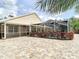 Expansive backyard with brick pavers, screened-in lanai, and decorative landscaping around the pool at 6716 Frontier Ln, Tampa, FL 33625