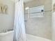 Updated bathroom featuring tiled walls, a shower-tub combo, and modern fixtures at 6716 Frontier Ln, Tampa, FL 33625