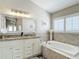 Beautiful bathroom with a soaking tub, marble countertops, and a large mirror, providing a luxurious experience at 6716 Frontier Ln, Tampa, FL 33625