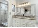 Elegant bathroom with double sinks, granite countertops, and a separate glass shower, offering a modern touch at 6716 Frontier Ln, Tampa, FL 33625