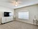 Cozy bedroom with neutral carpet, a ceiling fan, and a large window at 6716 Frontier Ln, Tampa, FL 33625