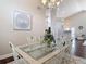 Elegant dining room with glass-top table, ornate chairs, chandelier, and modern artwork at 6716 Frontier Ln, Tampa, FL 33625