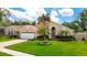 Beautiful single-story home with a manicured lawn, lush landscaping, and an inviting curb appeal at 6716 Frontier Ln, Tampa, FL 33625